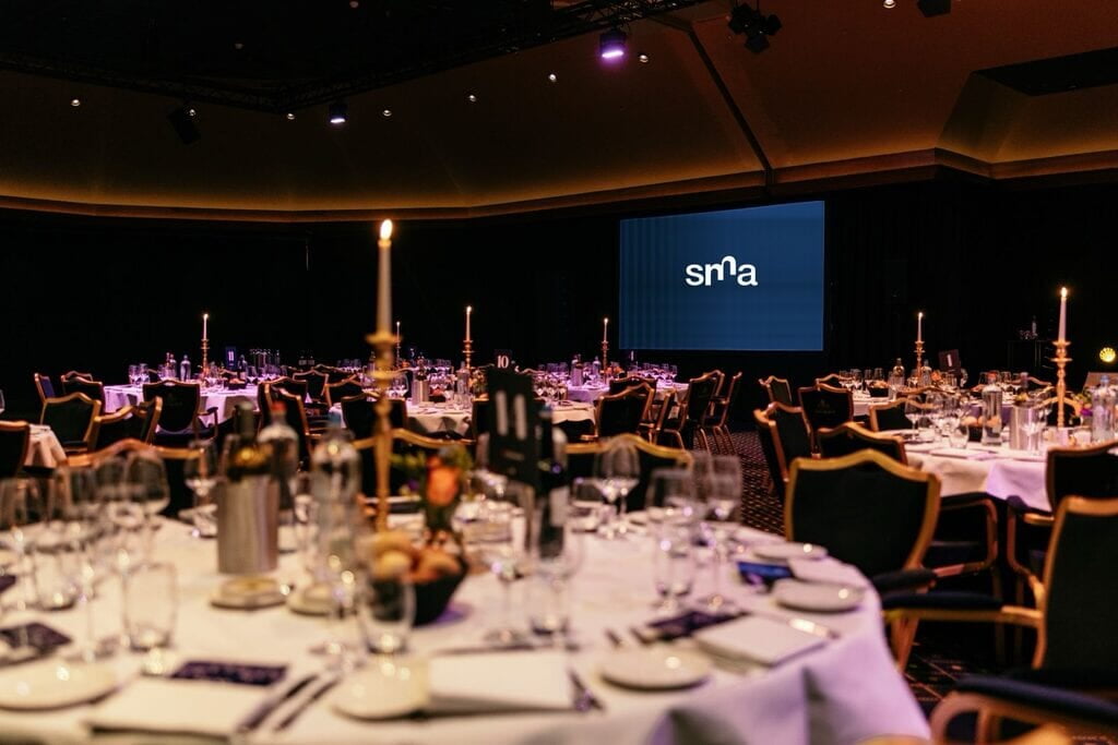 gedekte tafels in de zaal tijdens het SMA Captains Dinner