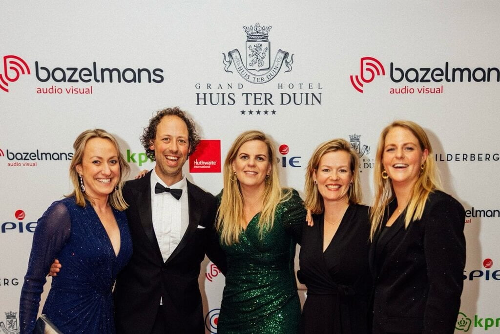 sponsorwand met logo's, vijf gasten ervoor